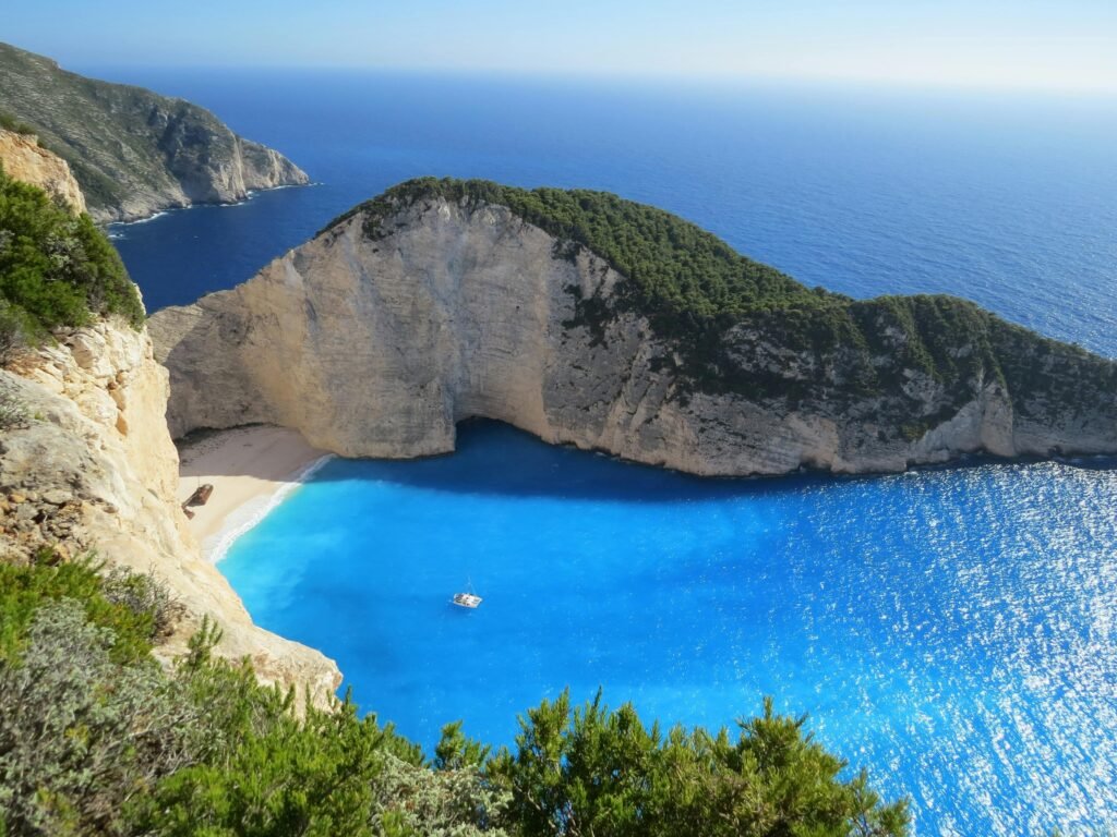 Aerial view of a dramatic coastal cliff and turquoise bay, representing a CME Travel Academy conference destination